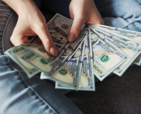 A person counting the money they received after comparing personal loans